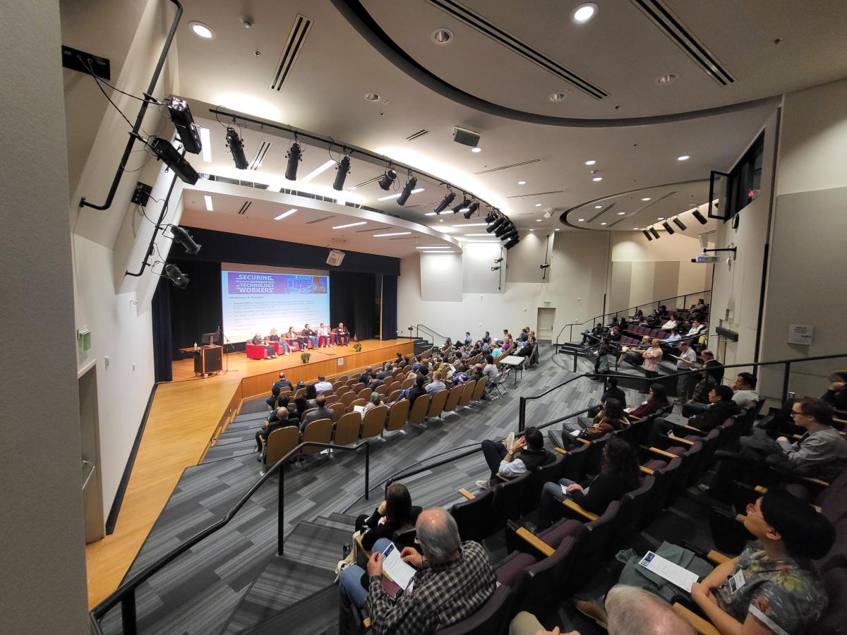 Auditorium of students and employers listen to a panel of experts discuss pathways to cybersecurity employment